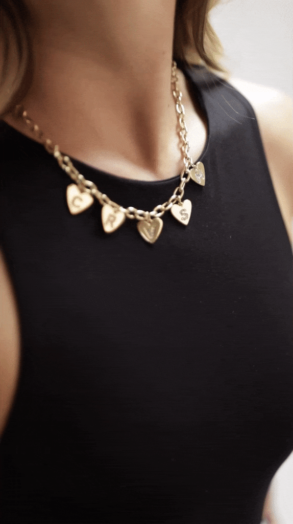 Collar MACARENA de la marca CRVSH, con 5 charms de corazón formando el nombre de la marca con cristales SWAROVSKI. Estaño bañado en oro 24K